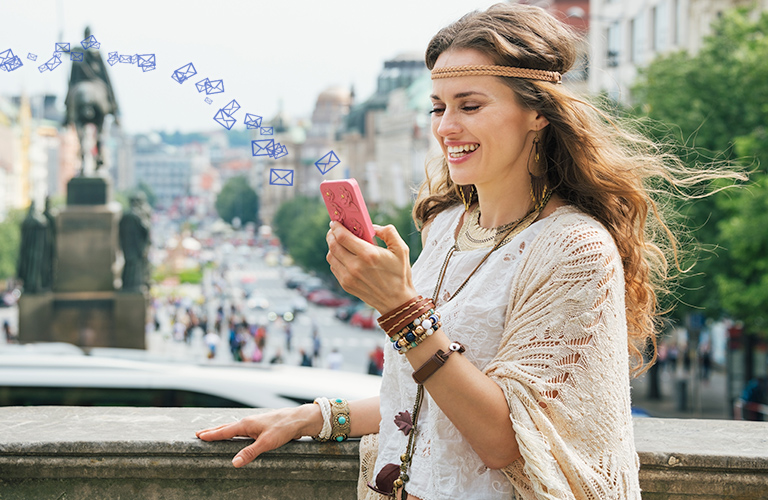 mujer con celular en la mano enviando sms internacional 768 x 500 pixeles
